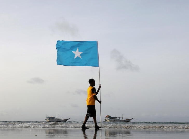 Somali youth holds the national flag, at Lido beach, Mogadishu's Abdiaziz District